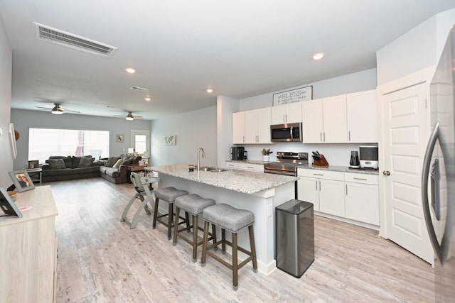 2004 Hardwick Ln, Gallatin, TN 37066 - kitchen with appliances with stainless steel finishes, ceiling fan, light wood-style floors, white cabinets, and recessed lighting