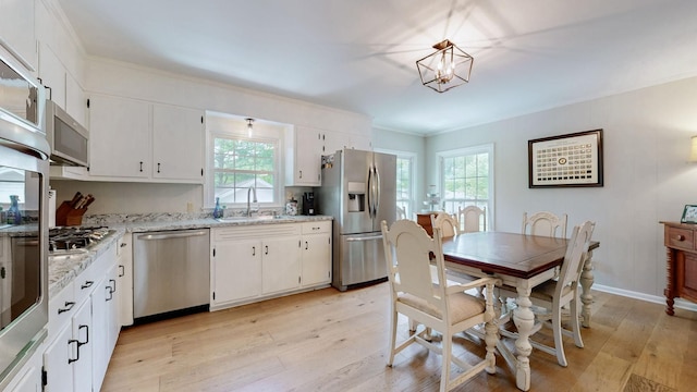 400 Westland Dr, Lebanon, TN 37087 - kitchen featuring stainless steel appliances, ornamental molding, light wood-type flooring, white cabinetry, and light stone counters