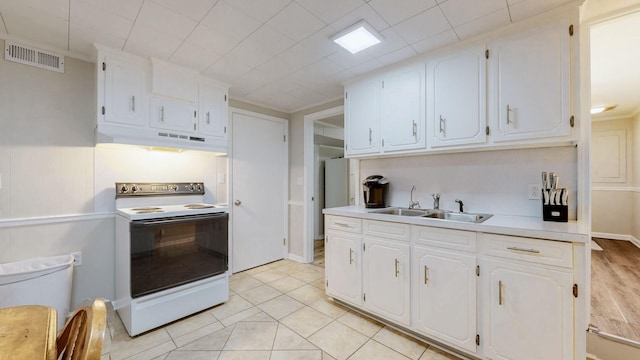 400 Westland Dr, Lebanon, TN 37087 - kitchen with electric range, under cabinet range hood, light countertops, white cabinetry, and light tile patterned floors
