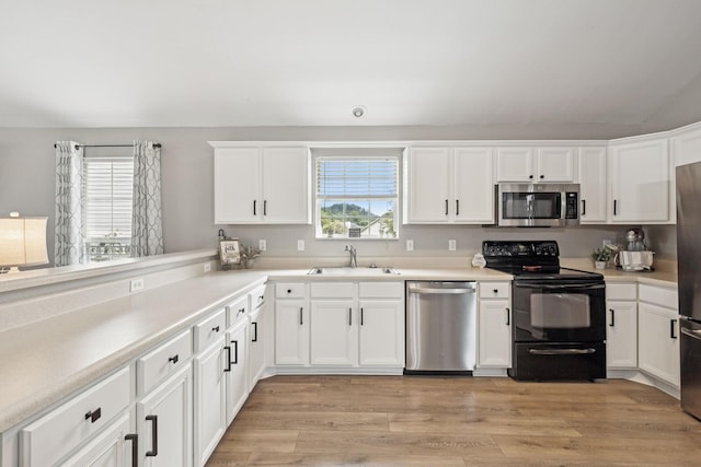 4012 Amber Way, Spring Hill, TN 37174 - kitchen with stainless steel appliances, white cabinetry, light countertops, and light wood-style floors