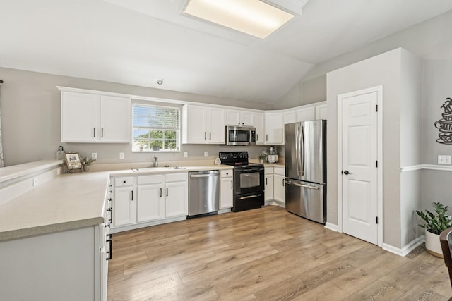 4012 Amber Way, Spring Hill, TN 37174 - kitchen with stainless steel appliances, light wood finished floors, light countertops, lofted ceiling, and white cabinets