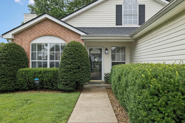 4012 Amber Way, Spring Hill, TN 37174 - entrance to property with a chimney, brick siding, roof with shingles, and a yard