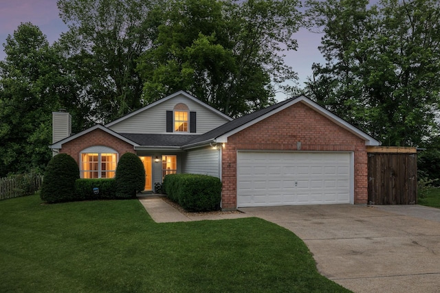 4012 Amber Way, Spring Hill, TN 37174 - traditional home with driveway, a garage, a yard, a chimney, and brick siding