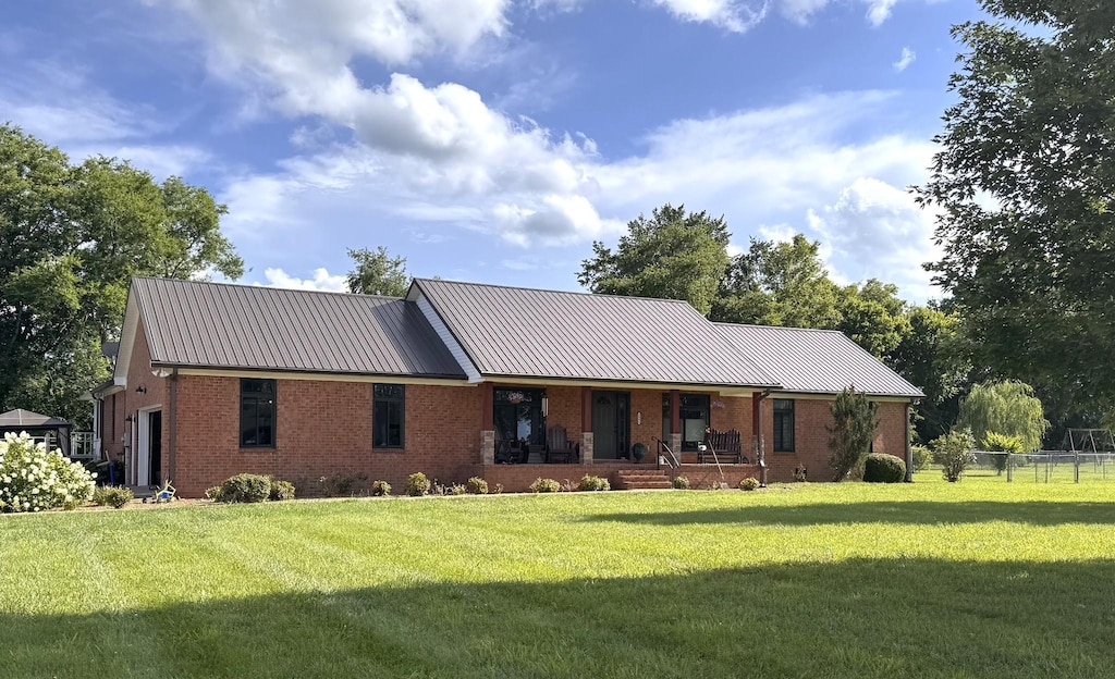 1904 Digg Ct, Columbia, TN 38401 - view of front of house featuring brick siding, covered porch, a metal roof, and an attached garage