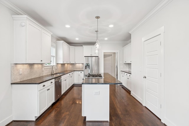 4704B Michigan Ave, Nashville, TN 37209 - kitchen featuring stainless steel appliances, a center island, white cabinetry, ornamental molding, and decorative backsplash