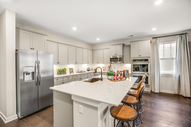 570 Gingerwood Ln, Hendersonville, TN 37075 - kitchen with stainless steel appliances, dark wood-type flooring, a breakfast bar area, light stone counters, and recessed lighting