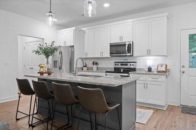9407 Hackberry Ln, Soddy Daisy, TN 37379 - kitchen with stainless steel appliances, a kitchen island with sink, a breakfast bar, white cabinets, and recessed lighting