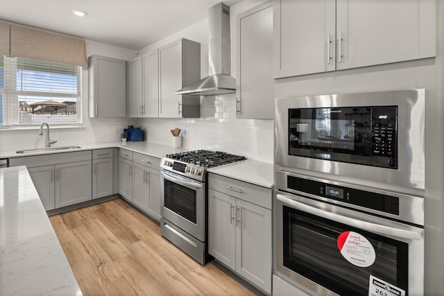 582 Gingerwood Ln, Hendersonville, TN 37075 - kitchen with appliances with stainless steel finishes, wall chimney range hood, gray cabinets, tasteful backsplash, and recessed lighting