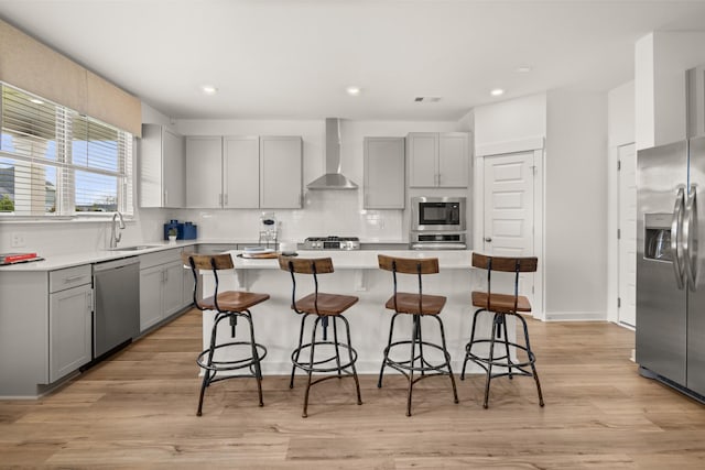 582 Gingerwood Ln, Hendersonville, TN 37075 - kitchen with gray cabinetry, appliances with stainless steel finishes, wall chimney range hood, recessed lighting, and a center island