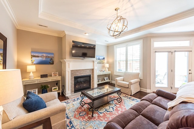 7040 Wenlock Ln, Franklin, TN 37064 - living area with wood finished floors, a raised ceiling, ornamental molding, a brick fireplace, and a chandelier