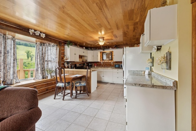 32 Morris Ln, Pleasant Shade, TN 37145 - kitchen with wooden ceiling, light tile patterned flooring, white cabinets, a kitchen bar, and ceiling fan