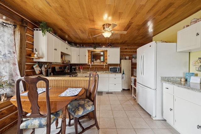 32 Morris Ln, Pleasant Shade, TN 37145 - kitchen with stainless steel microwave, stove, wooden ceiling, freestanding refrigerator, and light tile patterned floors
