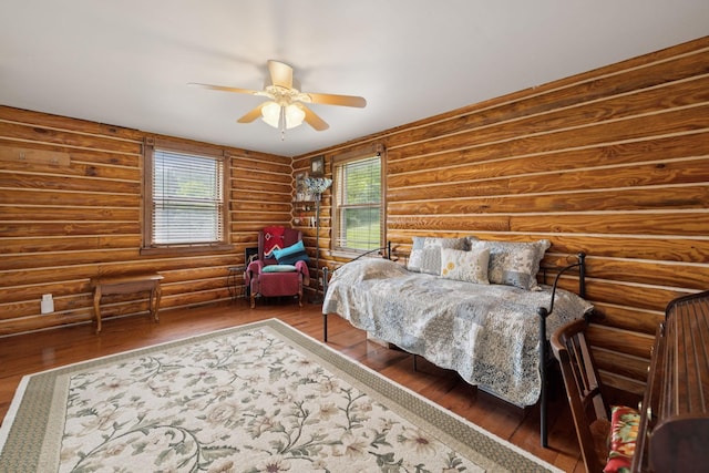32 Morris Ln, Pleasant Shade, TN 37145 - bedroom with wood finished floors, multiple windows, ceiling fan, and rustic walls