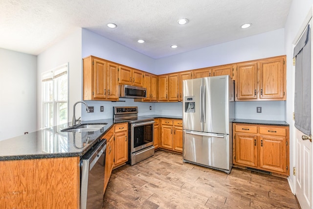 1622 Hickory Valley Rd, Lebanon, TN 37087 - kitchen with appliances with stainless steel finishes, light wood-type flooring, recessed lighting, brown cabinetry, and dark stone countertops