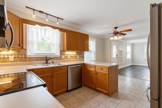 1519 Preston Dr, Nashville, TN 37206 - kitchen featuring appliances with stainless steel finishes, a peninsula, ceiling fan, crown molding, and backsplash