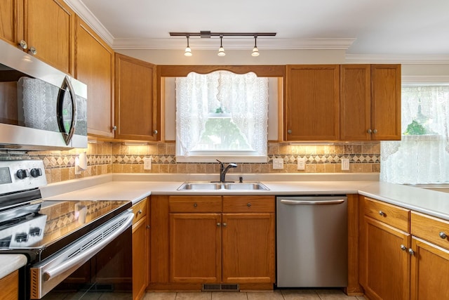 1519 Preston Dr, Nashville, TN 37206 - kitchen with appliances with stainless steel finishes, light countertops, decorative backsplash, and ornamental molding