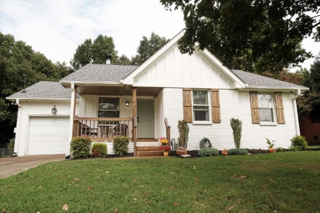 187 Bonnafield Dr, Hermitage, TN 37076 - ranch-style house featuring an attached garage, a porch, a front yard, board and batten siding, and brick siding