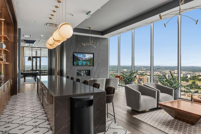 1616 W End Ave Unit 2609, Nashville, TN 37203 - kitchen with wood finished floors, a large island, a wall of windows, dark countertops, and hanging light fixtures