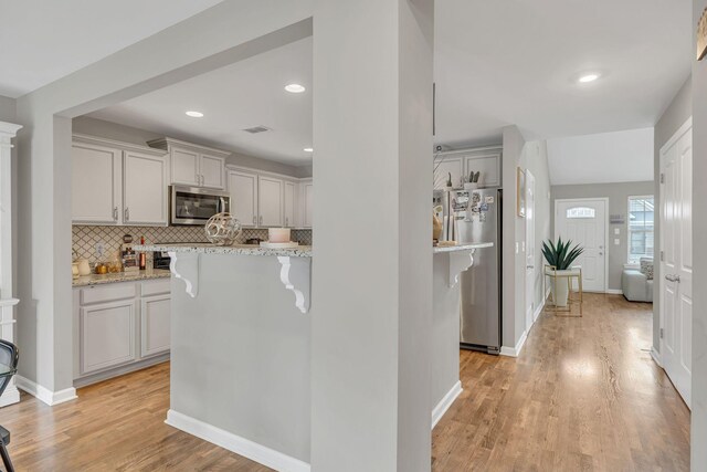 4418 Prometheus Way, Murfreesboro, TN 37128 - kitchen featuring appliances with stainless steel finishes, light wood-style flooring, decorative backsplash, light stone countertops, and recessed lighting