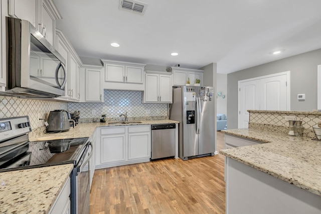 4418 Prometheus Way, Murfreesboro, TN 37128 - kitchen featuring stainless steel appliances, decorative backsplash, light wood-style flooring, light stone countertops, and recessed lighting