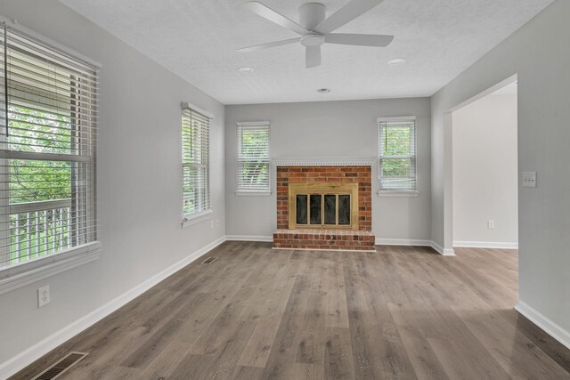 545 Old Lebanon Dirt Rd, Hermitage, TN 37076 - unfurnished living room with plenty of natural light, a brick fireplace, a ceiling fan, wood finished floors, and a textured ceiling
