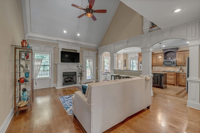 2711 Crowne Pointe Dr, Murfreesboro, TN 37130 - living area featuring ornate columns, ceiling fan, crown molding, arched walkways, and a fireplace with flush hearth