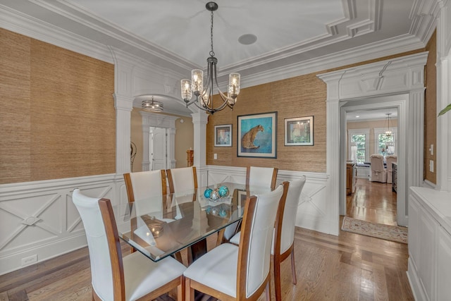 2711 Crowne Pointe Dr, Murfreesboro, TN 37130 - dining space featuring decorative columns, a chandelier, a decorative wall, wood finished floors, and ornamental molding