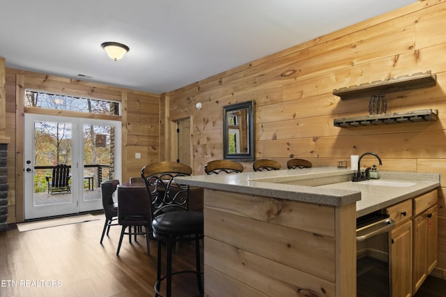 645 Bankston Ln, La Follette, TN 37766 - kitchen featuring wine cooler, wood walls, dark wood-style floors, a kitchen breakfast bar, and light stone counters