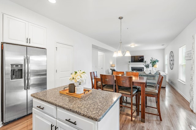 444 Heroit Dr, Spring Hill, TN 37174 - kitchen featuring stainless steel fridge with ice dispenser, light wood finished floors, stone counters, and a kitchen island