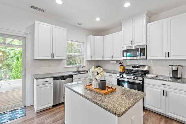 444 Heroit Dr, Spring Hill, TN 37174 - kitchen featuring stainless steel appliances, healthy amount of natural light, white cabinets, dark stone counters, and recessed lighting