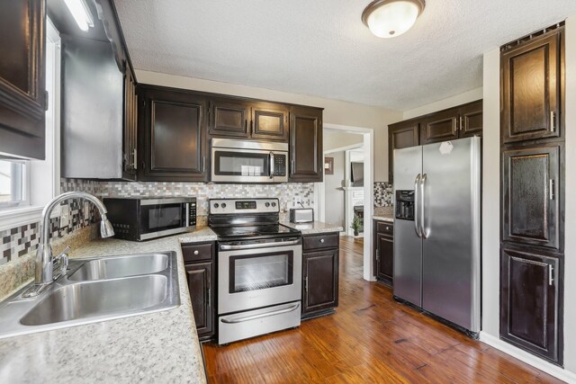 1287 Cheryl Ct, Clarksville, TN 37042 - kitchen featuring stainless steel appliances, light countertops, dark brown cabinetry, decorative backsplash, and a textured ceiling