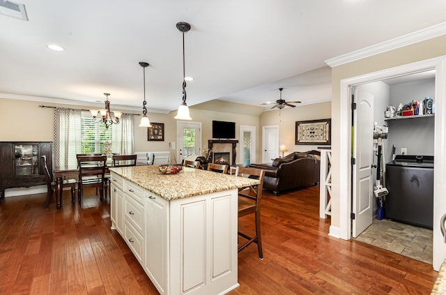 212 Hickory Pointe Dr, Lebanon, TN 37087 - kitchen with washer / dryer, a breakfast bar area, white cabinetry, ornamental molding, and a warm lit fireplace