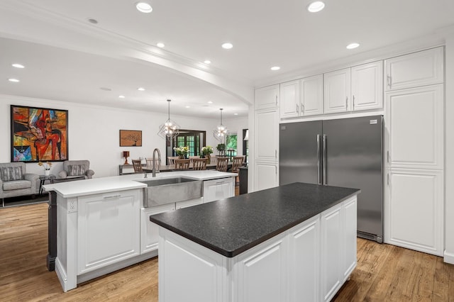 7871 Oscar Green Rd, Primm Springs, TN 38476 - kitchen featuring stainless steel appliances, an island with sink, white cabinets, light wood-style floors, and crown molding