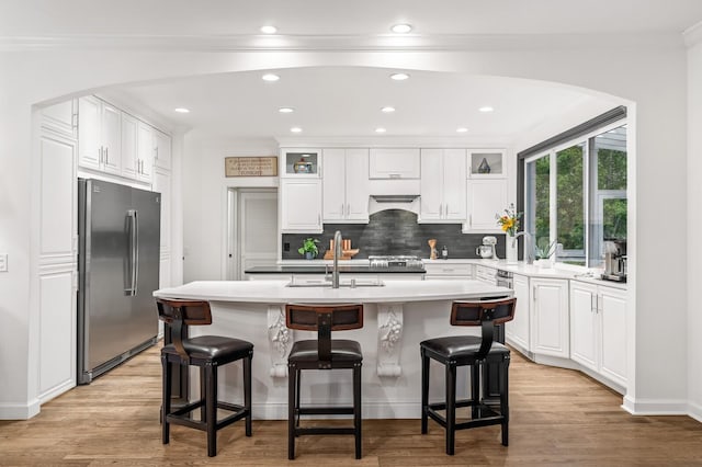 7871 Oscar Green Rd, Primm Springs, TN 38476 - kitchen featuring stainless steel fridge, decorative backsplash, white cabinets, glass insert cabinets, and light wood-type flooring