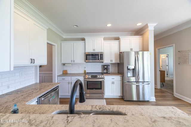 102 Chaseberry Rd, Oak Ridge, TN 37830 - kitchen featuring appliances with stainless steel finishes, ornamental molding, light stone counters, white cabinets, and decorative backsplash
