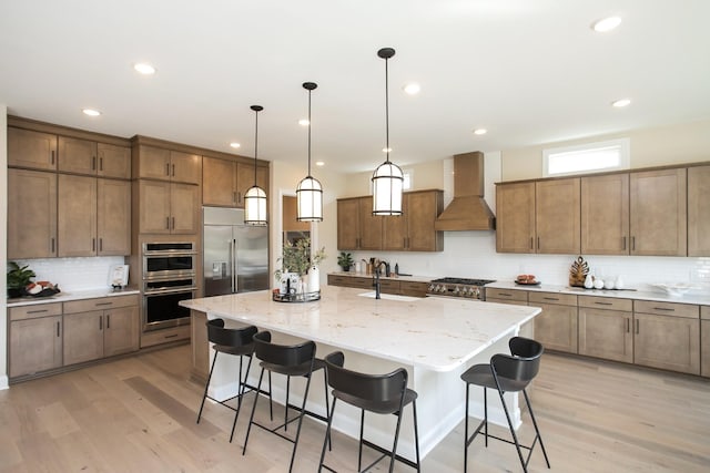1935 Harmony Rd, Spring Hill, TN 37174 - kitchen with custom exhaust hood, appliances with stainless steel finishes, tasteful backsplash, a kitchen breakfast bar, and a kitchen island with sink