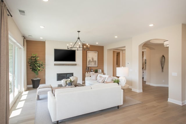 1935 Harmony Rd, Spring Hill, TN 37174 - living room featuring light wood-style floors, recessed lighting, arched walkways, a fireplace, and a chandelier