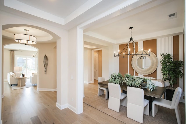 1935 Harmony Rd, Spring Hill, TN 37174 - dining space with a chandelier, a tray ceiling, and light wood-type flooring