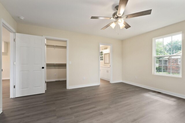 136 E School Dr, Rock Island, TN 38581 - unfurnished bedroom with dark wood finished floors, a spacious closet, ceiling fan, ensuite bathroom, and a closet