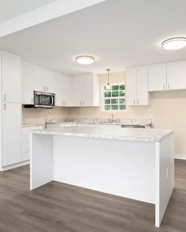 136 E School Dr, Rock Island, TN 38581 - kitchen with stainless steel microwave, white cabinets, dark wood-style floors, light countertops, and pendant lighting
