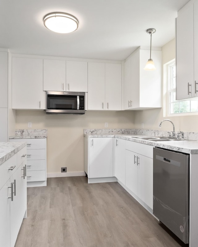 136 E School Dr, Rock Island, TN 38581 - kitchen featuring appliances with stainless steel finishes, light wood finished floors, white cabinets, pendant lighting, and light countertops