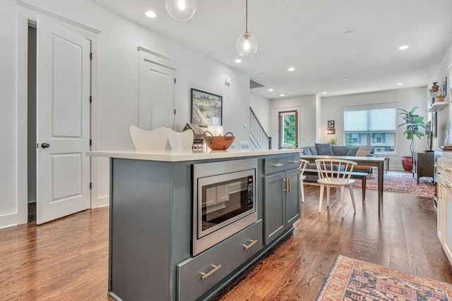 1510B 10th Ave N, Nashville, TN 37208 - kitchen with stainless steel microwave, gray cabinets, wood finished floors, open floor plan, and a center island