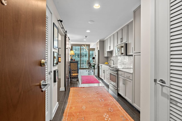 1212 Laurel St Unit 1510, Nashville, TN 37203 - kitchen with stainless steel appliances, a barn door, recessed lighting, dark wood-style floors, and gray cabinetry