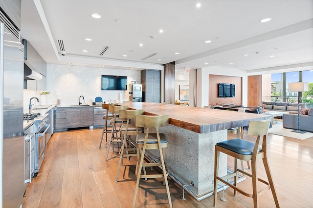 1212 Laurel St Unit 1510, Nashville, TN 37203 - kitchen featuring stainless steel stove, modern cabinets, light wood-type flooring, open floor plan, and wood counters