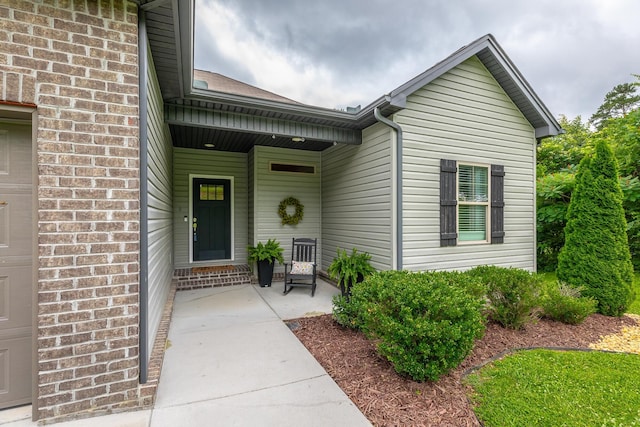 8624 Reba Ln, Hixson, TN 37343 - view of exterior entry featuring brick siding, an attached garage, and covered porch