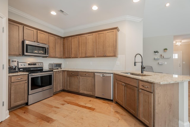 8624 Reba Ln, Hixson, TN 37343 - kitchen featuring stainless steel appliances, a peninsula, ornamental molding, backsplash, and light stone countertops