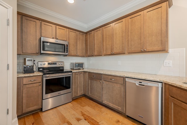 8624 Reba Ln, Hixson, TN 37343 - kitchen featuring appliances with stainless steel finishes, light wood finished floors, ornamental molding, decorative backsplash, and light stone countertops