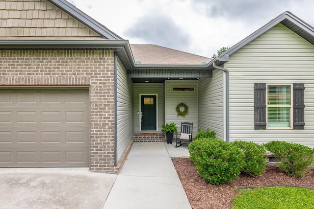 8624 Reba Ln, Hixson, TN 37343 - view of exterior entry with brick siding, a garage, and roof with shingles