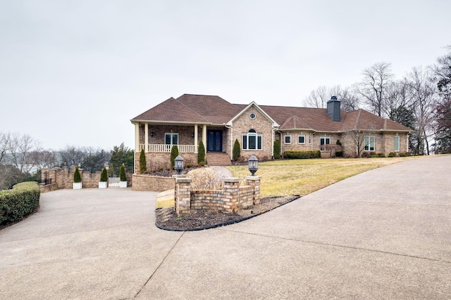 1825 Lake Meadow Trl, Mount Juliet, TN 37122 - view of front of house featuring a chimney, covered porch, a front yard, brick siding, and concrete driveway
