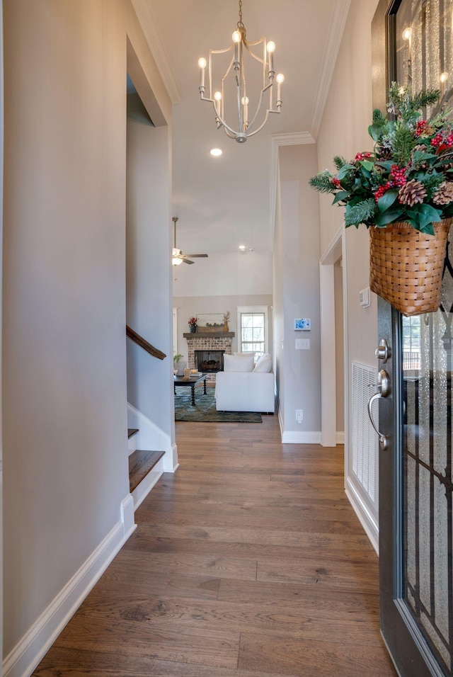 1052 Jackston Mack Way, Gallatin, TN 37066 - entrance foyer featuring ornamental molding, stairway, a fireplace, a chandelier, and wood finished floors